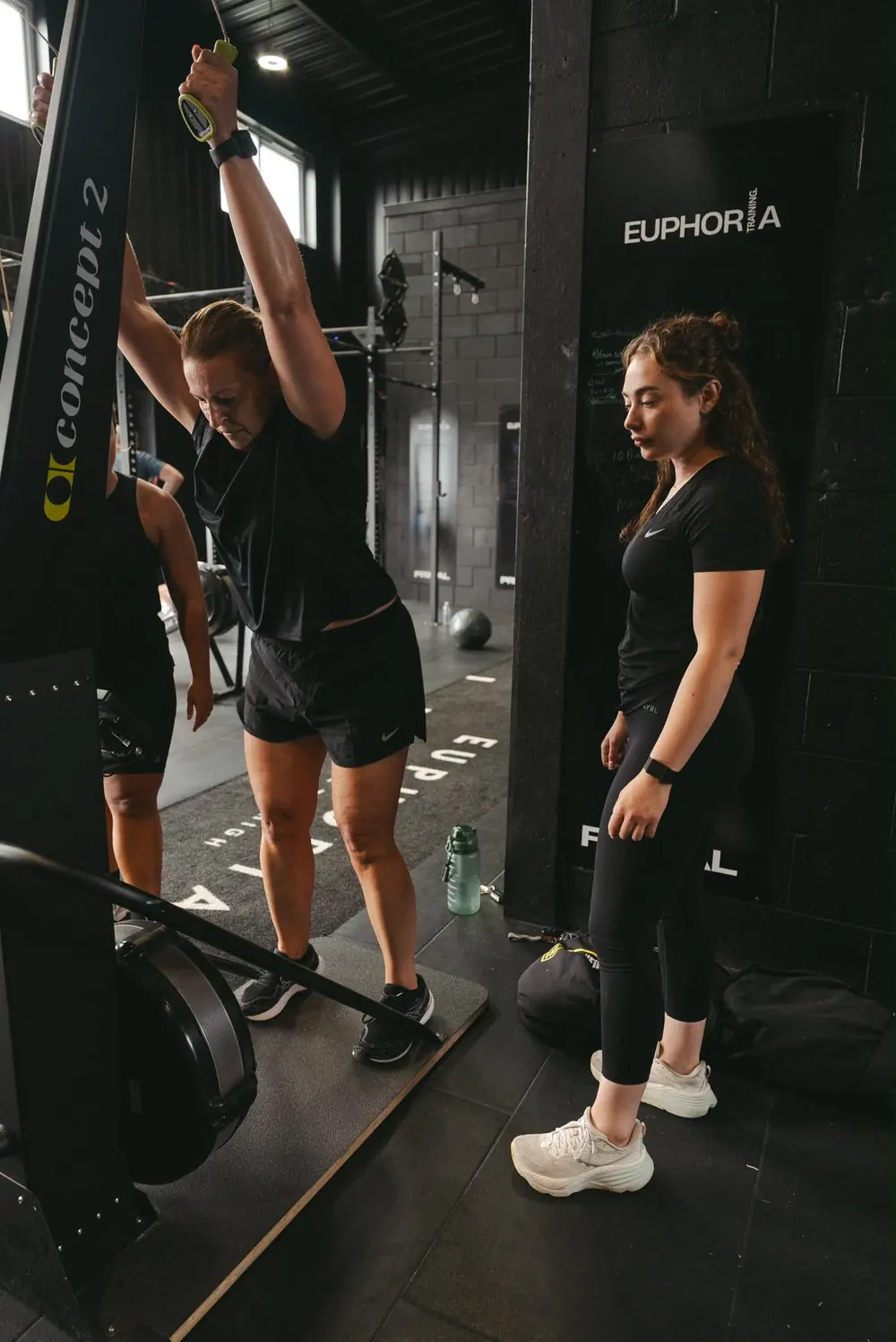 Coach watching a member on the ski erg