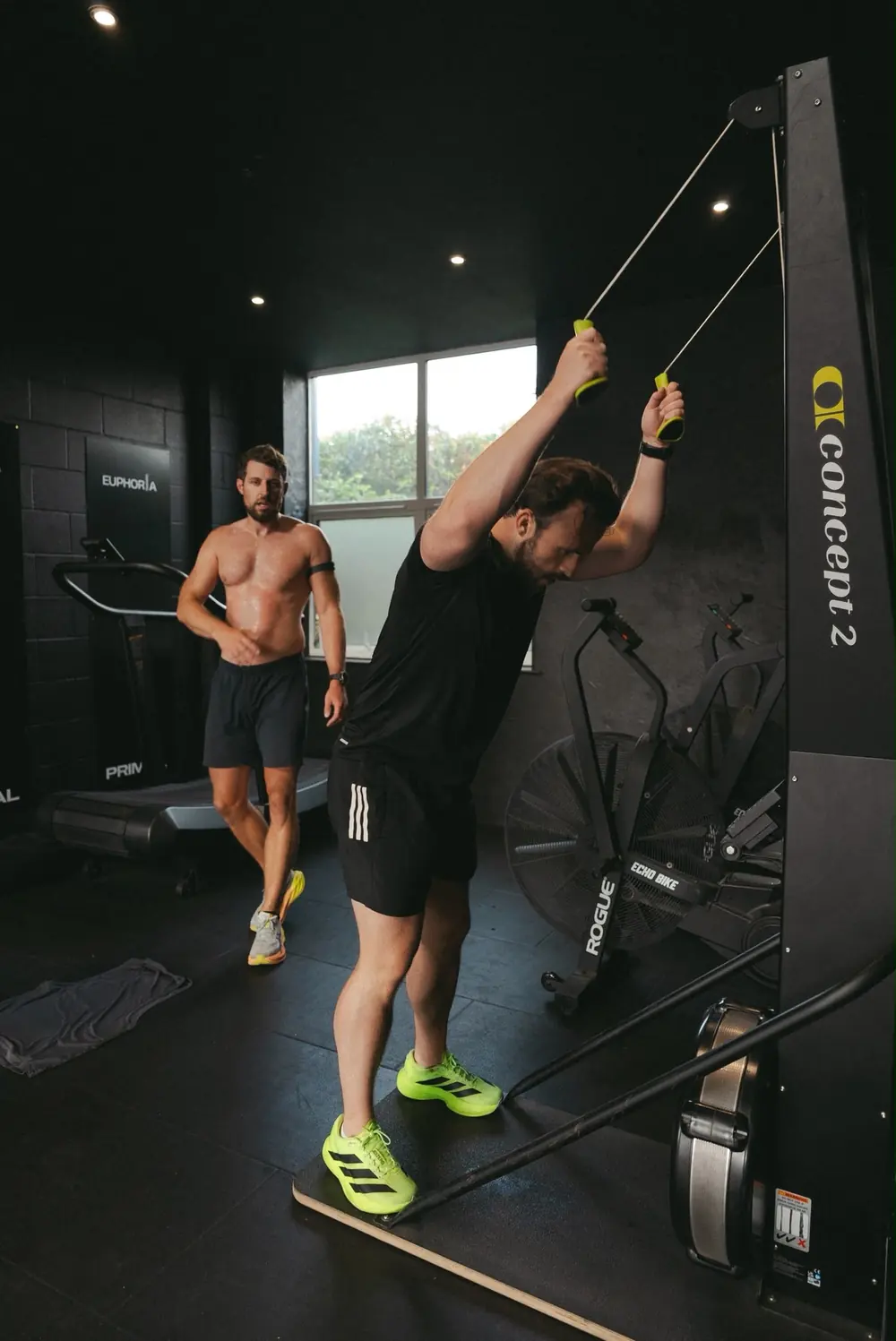 Member on the ski erg with another member warming up